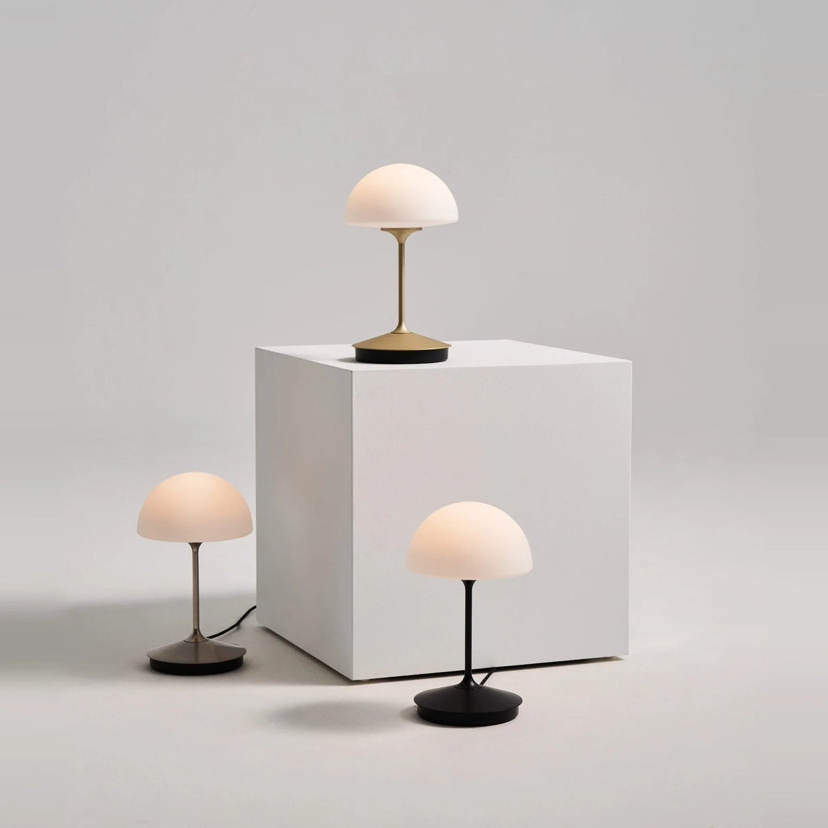Opal glass dome table lamp with dimmer, three lamps on a white plinth