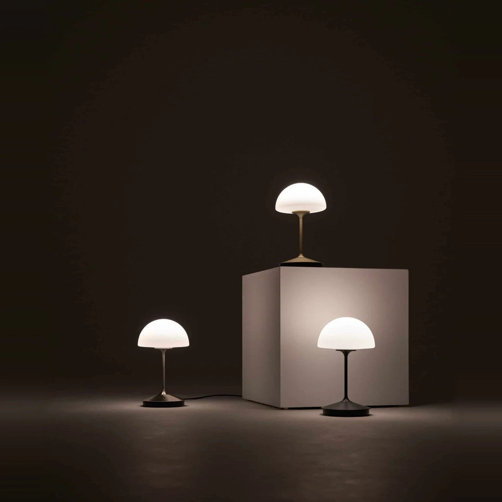 Opal glass dome table lamp with dimmer, lamps lit in a dark room