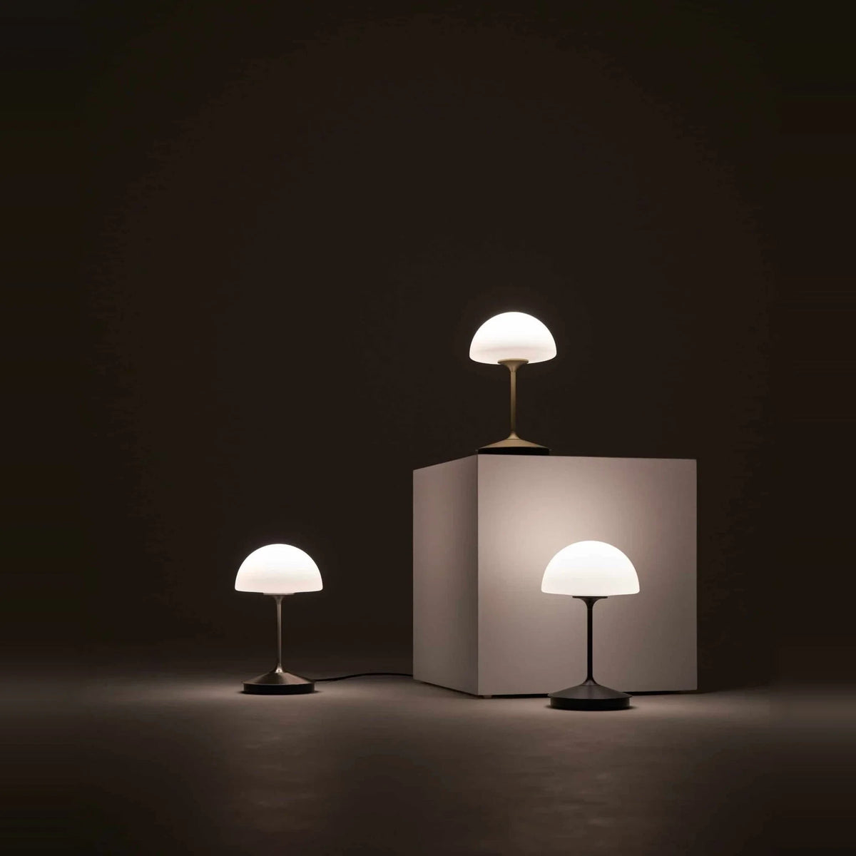 Opal glass dome table lamp with dimmer, lamps lit in a dark room