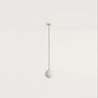 Opal glass globe pendant, with brass stem on a plain background