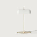 Opal glass shade table lamp with slim stem and oval base, in matte brass, on a plain background