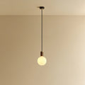 Opal globe pendant, dim-to-warm, walnut, lit, hung from the ceiling
