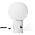 Glass globe table lamp with white marble-effect base, on a plain background