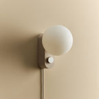Opal globe table lamp with wall mount option, Blossom, mounted on a wall, unlit