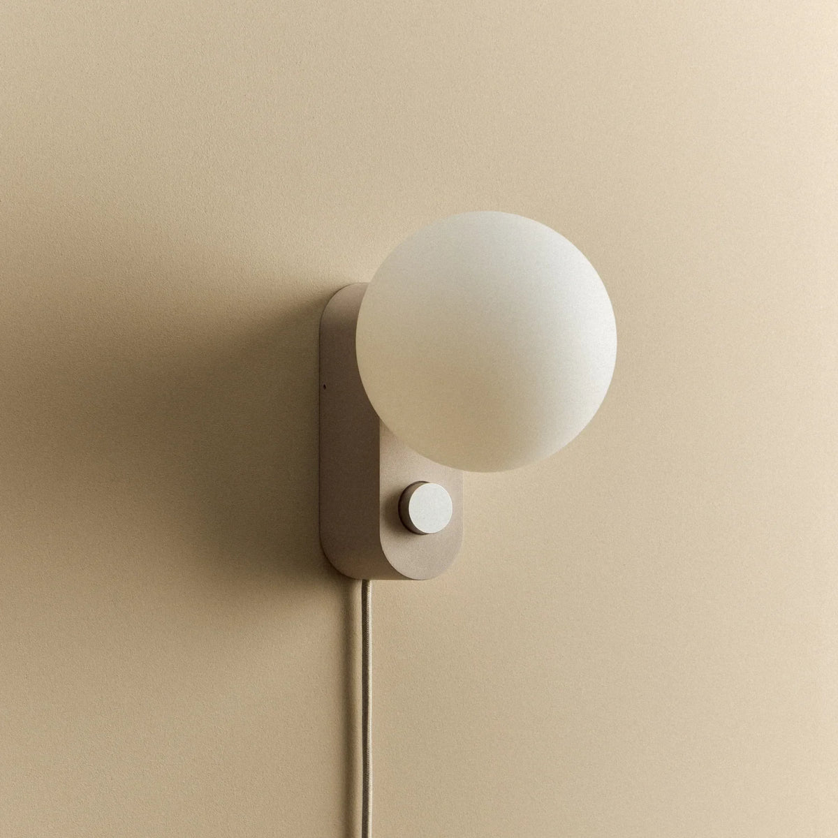 Opal globe table lamp with wall mount option, Blossom, mounted on a wall, unlit
