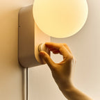 Opal globe table lamp with wall mount option, Blossom, turning the dimmer dial on the wall-mounted lamp