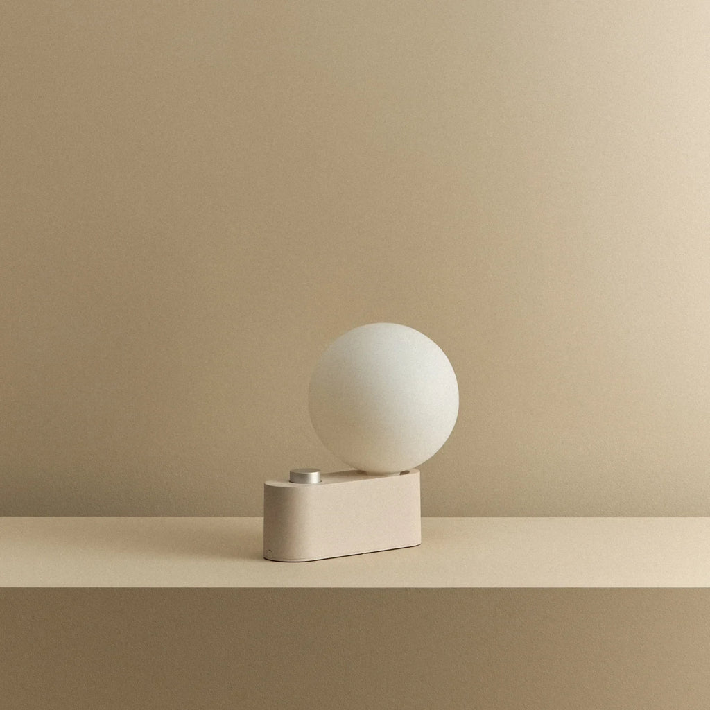 Opal globe table lamp with wall mount option, Blossom, on a shelf, unlit