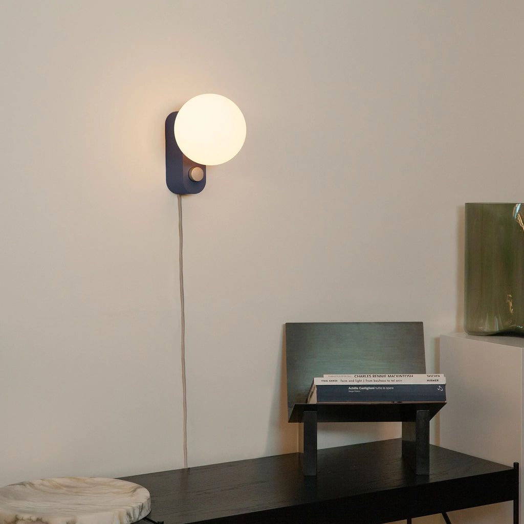 Opal globe table lamp with wall mount option, Sapphire, mounted on a wall above a desk