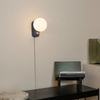 Opal globe table lamp with wall mount option, Sapphire, mounted on a wall above a desk