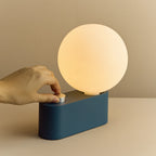Opal globe table lamp with wall mount option, Sapphire, turning the dimmer dial on the base
