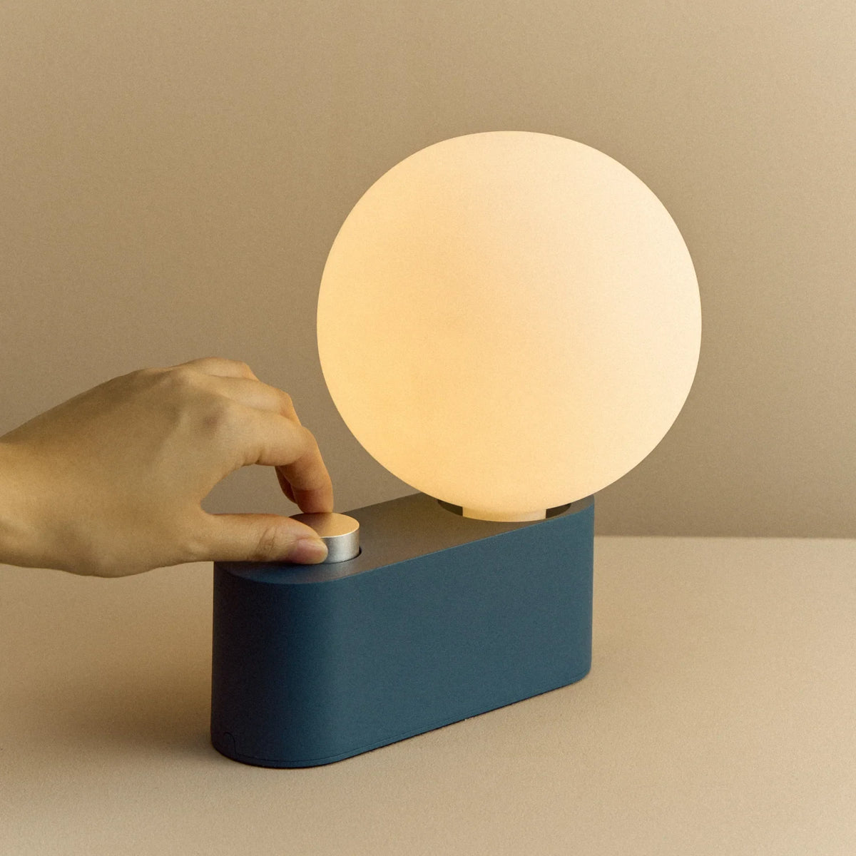 Opal globe table lamp with wall mount option, Sapphire, turning the dimmer dial on the base