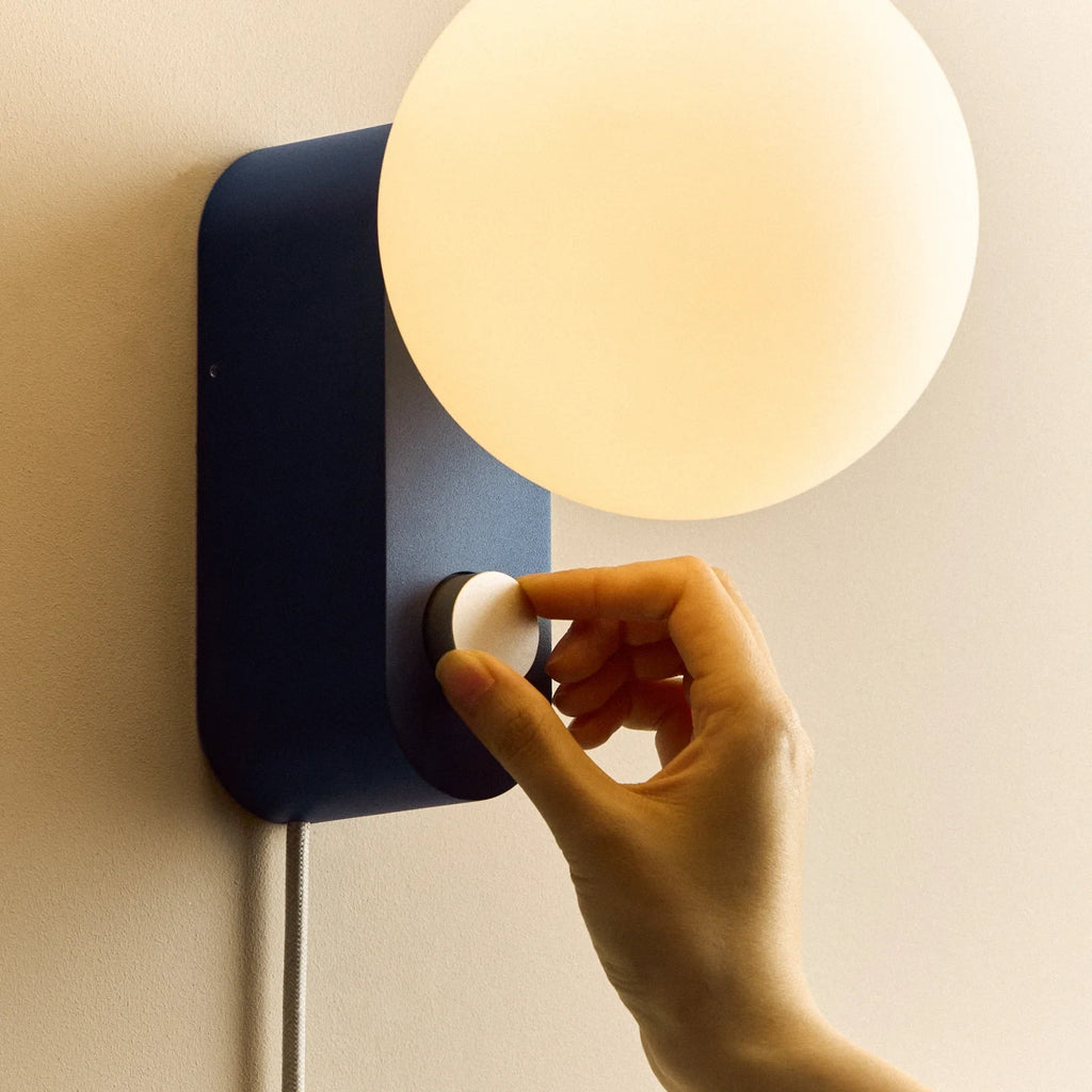 Opal globe table lamp with wall mount option, Sapphire, turning the dimmer dial on the wall-mounted lamp