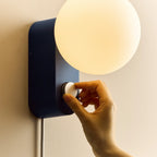 Opal globe table lamp with wall mount option, Sapphire, turning the dimmer dial on the wall-mounted lamp