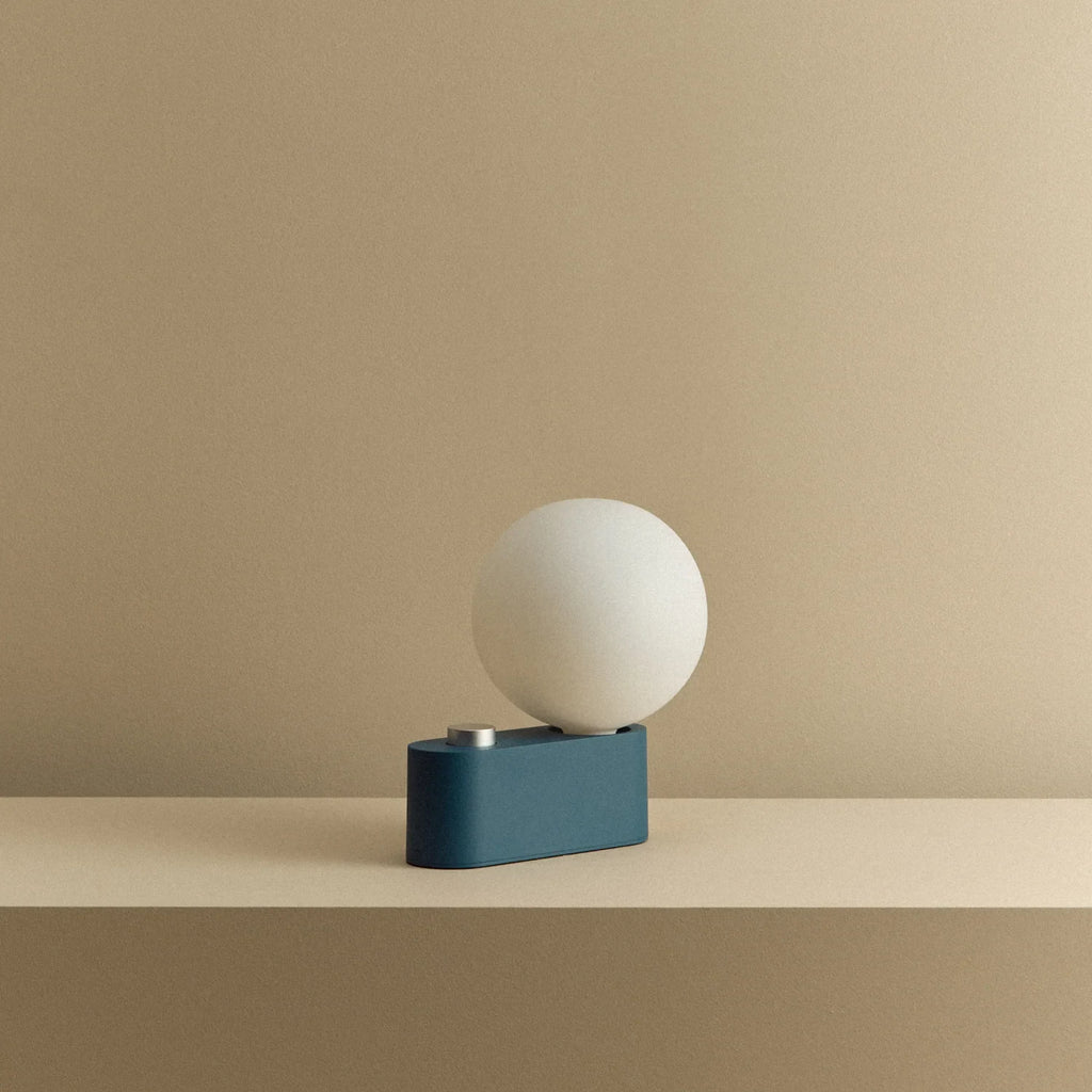 Opal globe table lamp with wall mount option, Sapphire, on a shelf, unlit