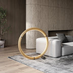 Circular opal ring floor lamp, matte black, lit, beside a sofa in a living room
