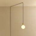 Opal sphere bulb plug-in pendant, in brass, routed across the ceiling and down the wall