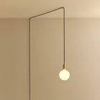 Opal sphere bulb plug-in pendant, in brass, routed across the ceiling and down the wall