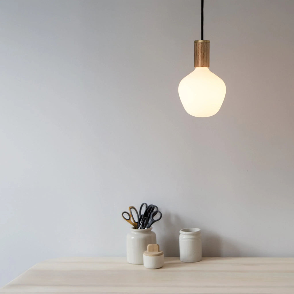 Opal Trapezoid Bulb Pendant, lit above a desk