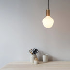 Opal Trapezoid Bulb Pendant, lit above a desk