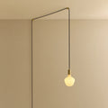 Opal trapezoid bulb plug-in pendant, in brass, routed across the ceiling and down the wall