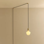 Opal trapezoid bulb plug-in pendant, in brass, routed across the ceiling and down the wall