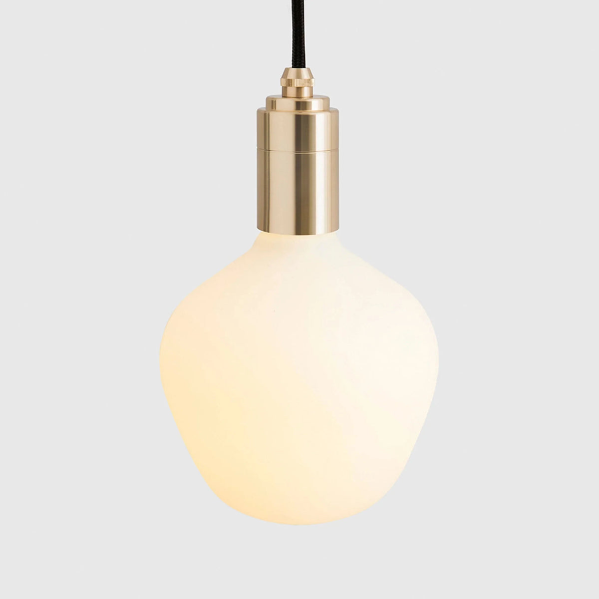 Opal trapezoid bulb plug-in pendant, close-up of the bulb and brass holder