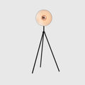 Oversize shade tripod floor lamp with black steel tripod, on a plain background