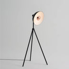 Oversize shade tripod floor lamp with black steel tripod, on a plain background, from the side