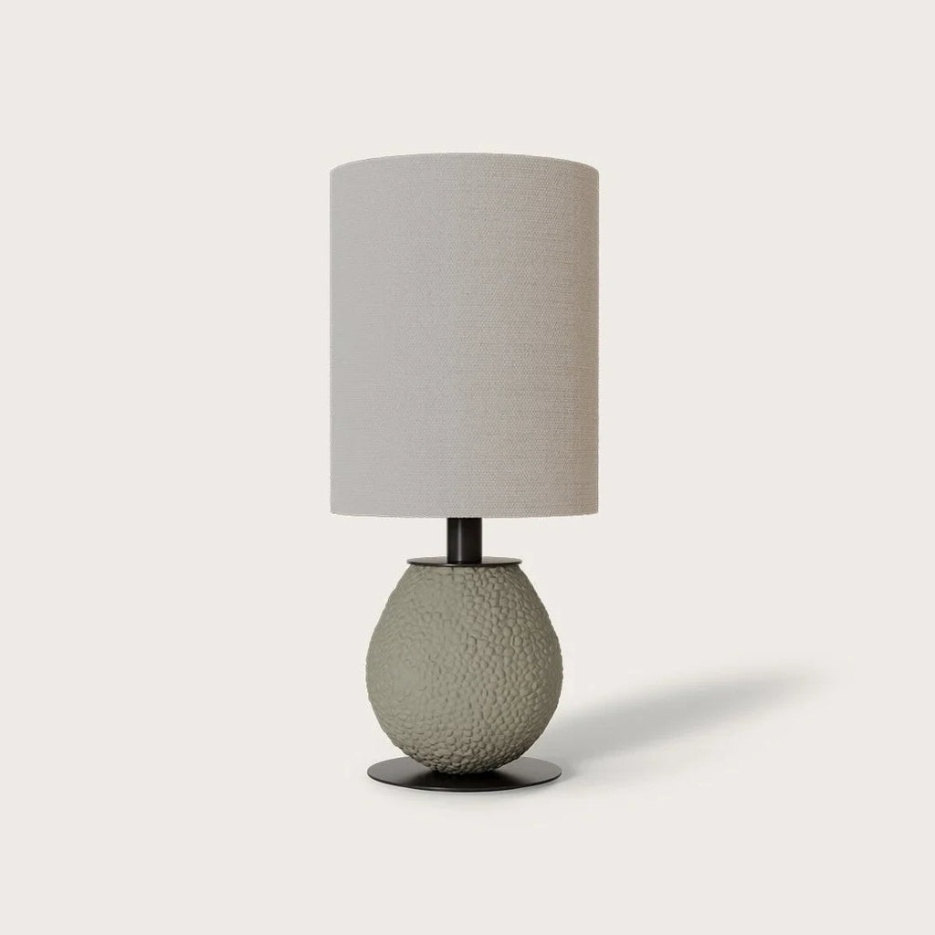 Pebbled ceramic egg-shaped table lamp base, shown with a drum shade (sold separately), on a plain background
