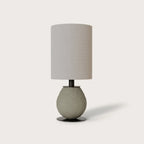 Pebbled ceramic egg-shaped table lamp base, shown with a drum shade (sold separately), on a plain background