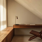 Pivoting spotlight table lamp with leather and ribbed metal head, in an aged gold finish, with a brown leather head, on a wooden desk