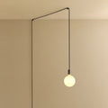 Plug-in pendant with opal globe bulb, graphite, lit, hung from a wall node