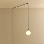 Plug-in pendant with opal globe bulb, graphite, lit, hung from a wall node