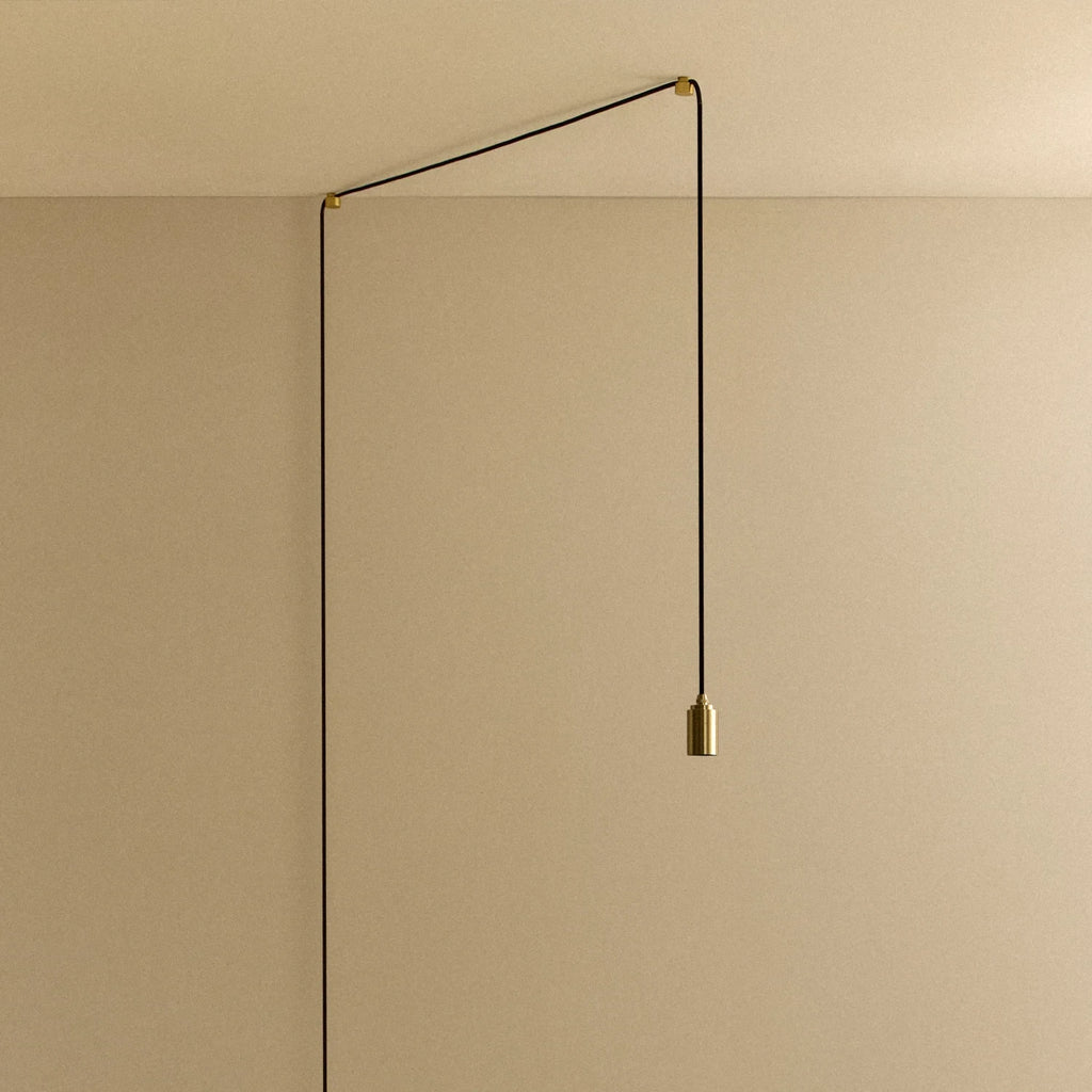 Plug-in brass pendant, cable routed across wall and ceiling