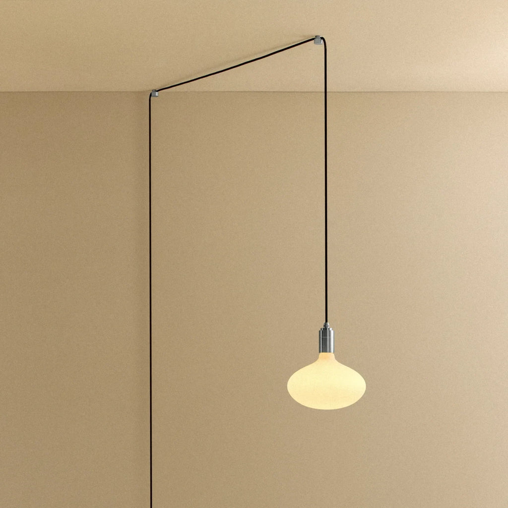 Plug-in pendant with large opal oval bulb, stainless steel, cable routed across wall and ceiling