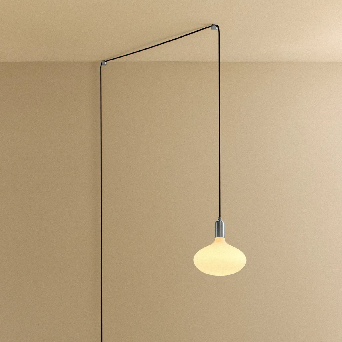 Plug-in pendant with large opal oval bulb, stainless steel, cable routed across wall and ceiling