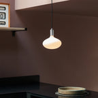 Plug-in pendant with large opal oval bulb, stainless steel, above a kitchen counter