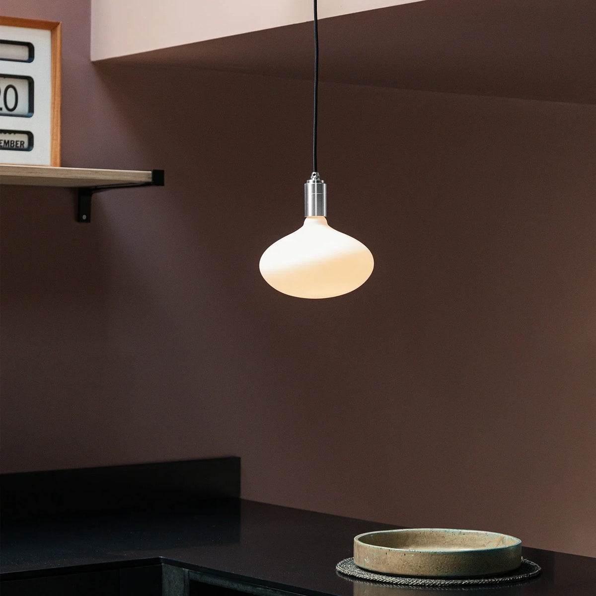 Plug-in pendant with large opal oval bulb, stainless steel, above a kitchen counter