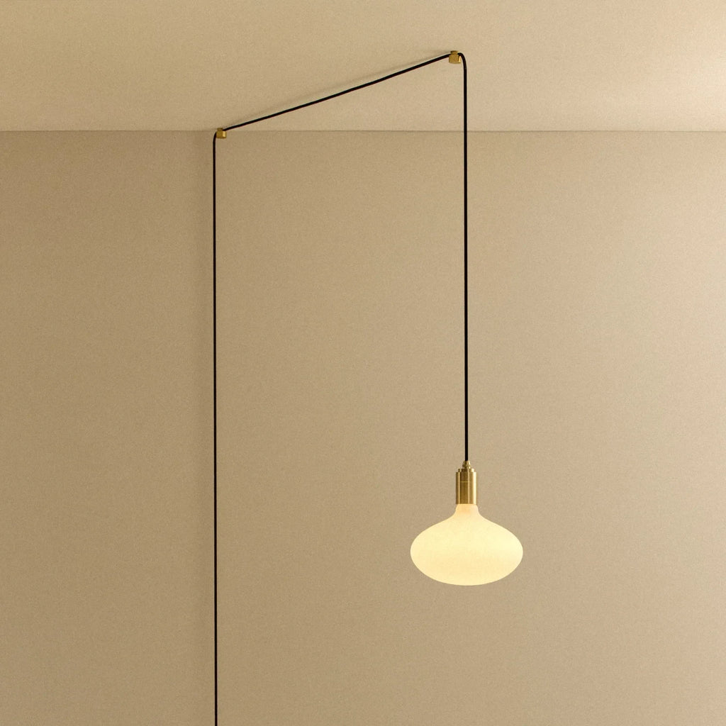 Plug-in pendant with opal oval bulb, brass, cable routed across wall and ceiling