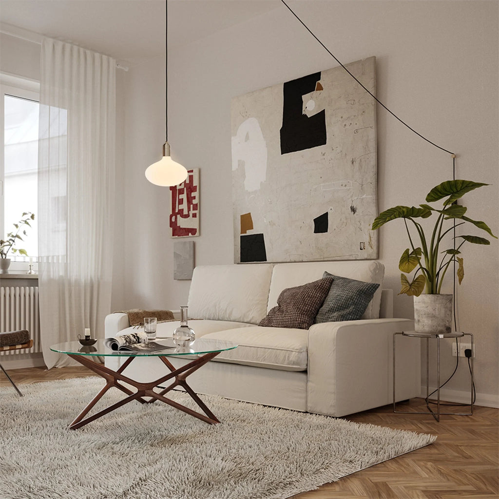 Plug-in pendant with opal oval bulb, brass, in a living room