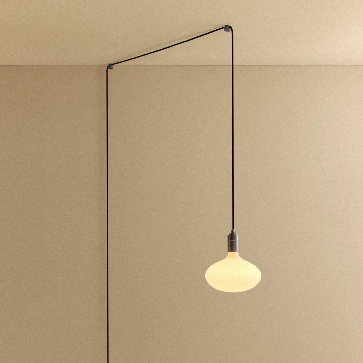 Plug-in pendant with opal oval bulb, graphite, cable routed across wall and ceiling