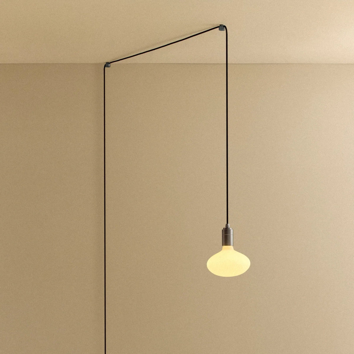 Plug-in pendant with small opal oval bulb, graphite, cable routed across wall and ceiling