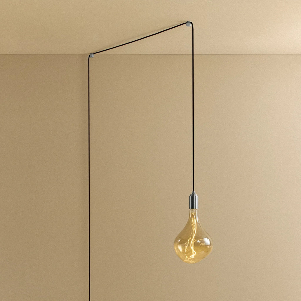 Plug-in pendant with tinted sculptural bulb, stainless steel, cable routed across wall and ceiling