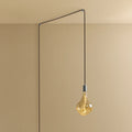 Plug-in pendant with tinted sculptural bulb, stainless steel, cable routed across wall and ceiling