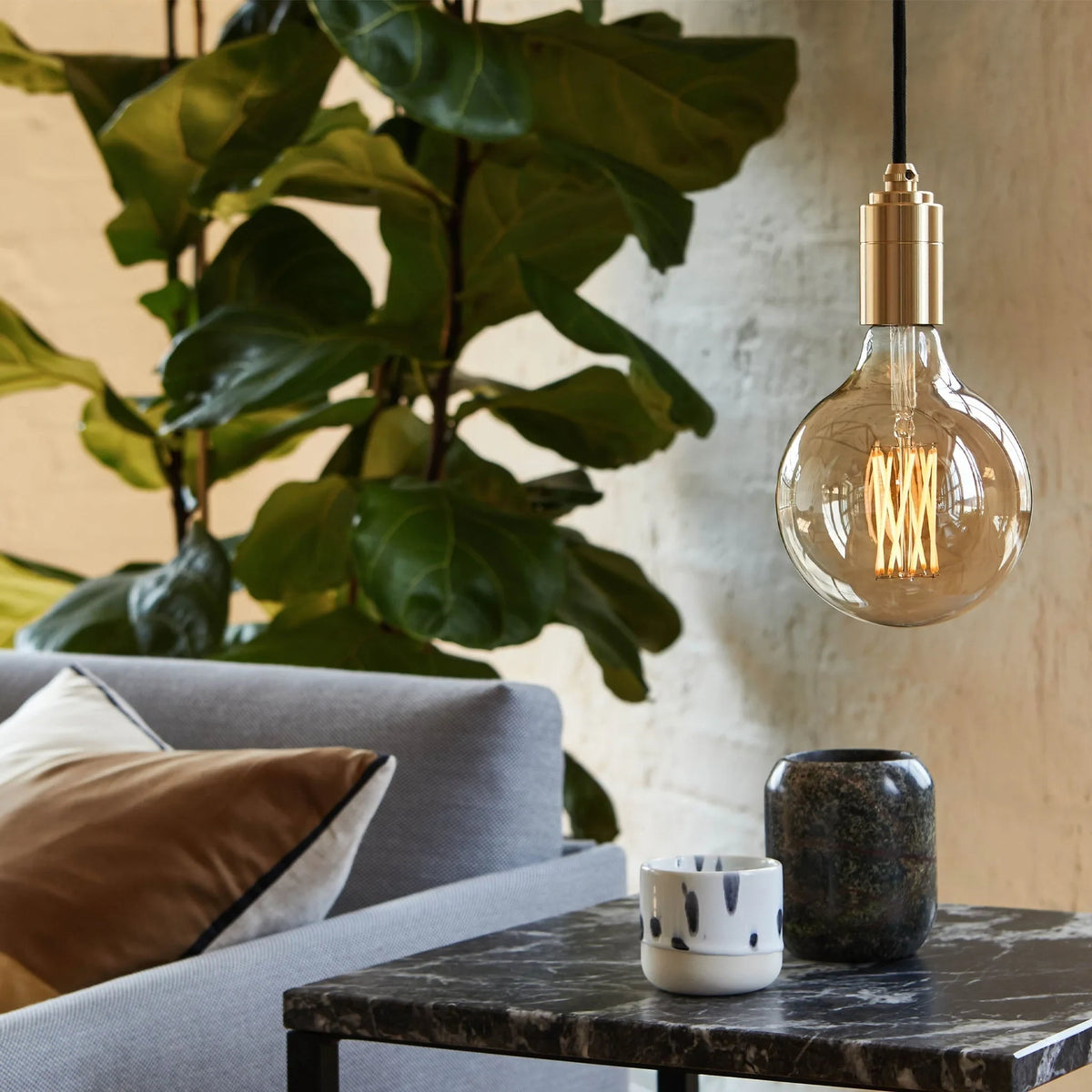 Plug-in pendant with tinted glass globe bulb, graphite, over a side table in a living room