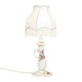 Porcelain table lamp with gold seams and a fringed shade, on a white background