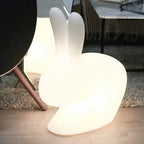 Cordless rabbit table lamp, translucent, lit beside a sofa