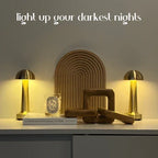 Small mushroom cordless table lamp, a pair in gold, lit on a sideboard