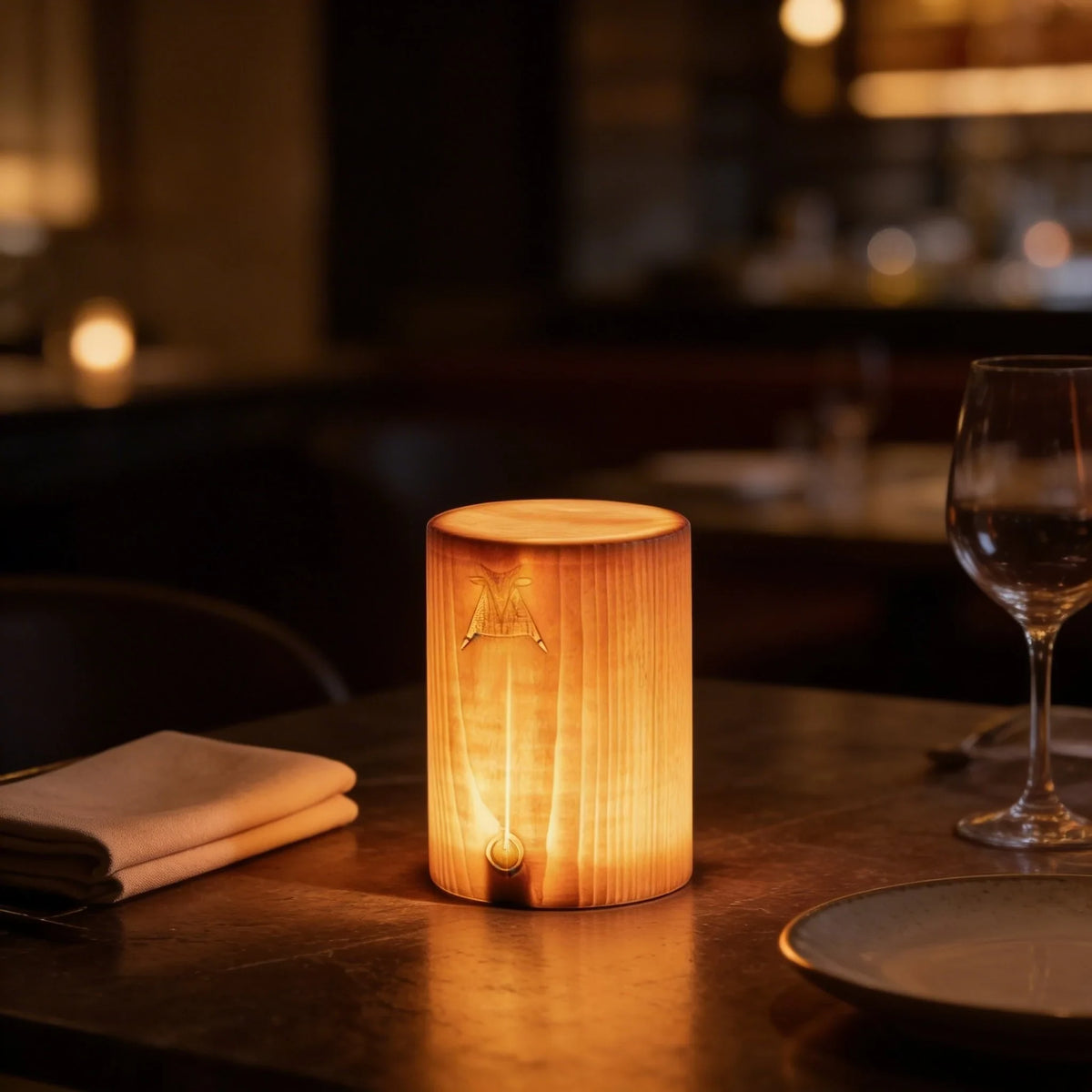 Rechargeable pine wood table lamp, lit on a dining table