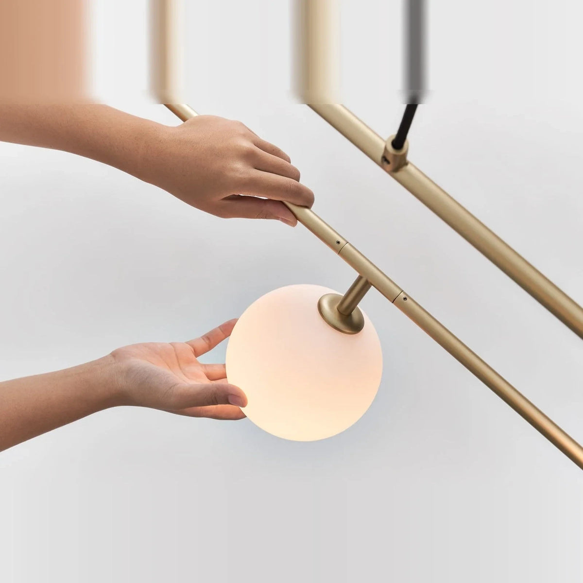 Rectangular Frame Four-Globe Linear Pendant, globe being turned by hand